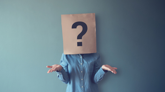 Person with a paper bag showing a question mark over their head, shrugging against a blue background, symbolizing confusion.