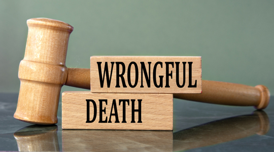 Wooden judge’s gavel resting beside blocks labeled “Wrongful Death,” symbolizing a legal case involving fatal negligence.